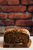 Delicious wholegrain bread on cutting board on table