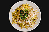 Appetizing tasty hot soya noodles on white plate in Asian restaurant