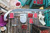 Top view of ripe sweet raspberries in plastic containers placed near digital scales for measuring weight