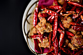 Draufsicht auf eine Korbschüssel mit Hähnchen-Chili-Paprika-Gericht