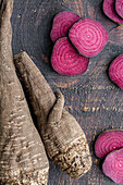 Overhead composition of organic natural beetroot cut into slices and arranged on shabby wooden surface