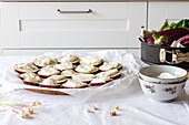 Prozess der Zubereitung hausgemachter Vorspeisen mit Auberginen, die mit Käse auf Backpapier eingefettet sind, in der Küche