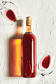 Draufsicht auf ein Arrangement von feinem Rotwein, der auf einer rissigen Oberfläche inmitten von Weingläsern liegt