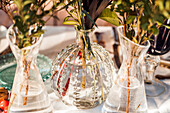 Hoher Winkel von transparenten Glasvasen mit Sträußen frischer Blumen auf dem Tisch für eine Veranstaltung