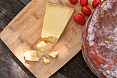 Von oben köstlicher italienischer Pecorino toscano-Käse mit Kirschtomaten auf Schneidebrett auf Holztisch serviert