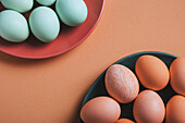 Draufsicht auf zwei Teller mit pastellfarbenen Ostereiern, die auf ein festliches Frühlingsfest hinweisen. Die beruhigenden Farbtöne und die minimalistische Komposition erinnern an den fröhlichen Geist des Osterfestes.