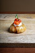 Elegant baby potato canapé topped with mozzarella cheese and a grilled red pepper, garnished with a fresh green sprout.