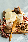 A rustic cheese board featuring slices of artisan cheese, almonds, red berries, and honey jars, with a spreader on the side