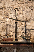 Antique scales in front of a rustic house wall