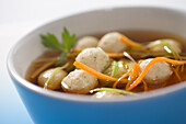 Marrow dumpling soup with broth and vegetable strips