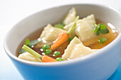 Cappelletti in broth with sugar peas and carrots