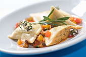 Maultaschen with salmon filling on paprika vegetables with rosemary and thyme