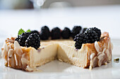 Cream cake with blackberries and almond slivers