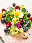 Salad with berries, cashew nuts and edible flowers