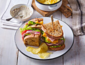 Ham and cheese sandwich with salad and crisps