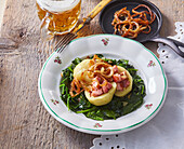 Potato dumplings stuffed with smoked pork on spinach