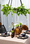 Table setting with glass vases and hanging plant decorations