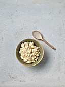 Bowl of fresh cottage cheese and wooden spoon