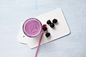 Blackberry and oat smoothie on a chopping board