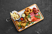 Beer snack platter with meat, onion rings and dips