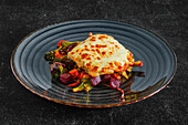 Baked cod fillet with cheese topping on beetroot, carrots and broccoli