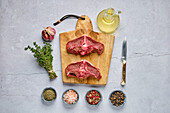 Raw venison saddle steaks with spices and herbs