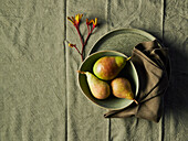 Three pears in a bowl on linen cloth