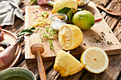 Whole and sliced lemons on wooden board