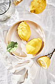Ganze und aufgeschnittene Zitronen auf Teller