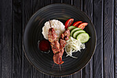 Shashlik skewers with rice, tomatoes, cucumber and onions