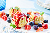 Mini cakes with raspberry sauce and berries