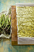 Preparing asparagus in puff pastry; pastry coated with pesto