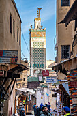 Das Minarett der Chrabliyine-Moschee überragt die belebten Straßen der Medina von Fez.