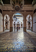 Besucher erkunden die historische Cherratine Madrasa in der belebten Medina von Fes.
