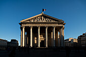 Die untergehende Sonne wirft Schatten auf die große neoklassizistische Fassade des Panthéons in Paris.