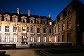 Hotel de Sully, a private mansion in the Marais, Paris, illuminated at dusk.