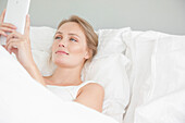 Woman In Bed Using Smart Phone