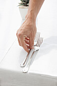 Close up of Waiter's Hand Arranging Cutlery on Restaurant Table
