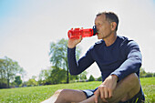 Mature Man Drinking from Water Bottle in Park