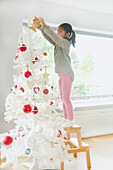 Young Girl Decorating Christmas Tree