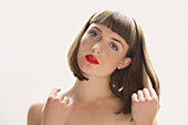 Close up of Young Woman with Red Lips Touching her Hair