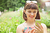 Close up of Smiling Teenage Girl Using Smartphone Outdoors