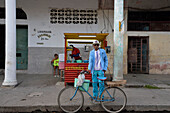Kuba, Ostregion, Bayamo, ein blau gekleideter Mann posiert vor seinem blauen Fahrrad