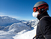 Österreich,Tirol,Sankt Anton am Arlberg Skigebiet,ein Mann trägt einen Skihelm,eine Sonnenbrille und eine Covid-Schutzmaske FFP2