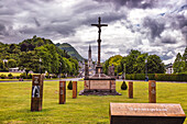 LOURDES - JUNE - 15 - 2019: Christian cross on a background the Basilica of our Lady of the Rosary in Lourdes,France