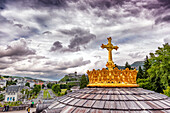 LOURDES - JUNE - 15 - 2019: Christian cross on a background the Basilica of our Lady of the Rosary in Lourdes,France
