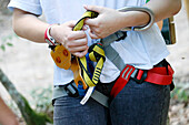 France. Seine et Marne. Summer holidays. 13 year old teenage girl doing tree climbing. Close-up of the safety harness.