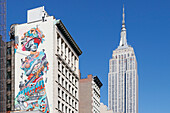 USA. New York City. Manhattan. Empire State Building. View from the streets. Street art is visible in the foreground.