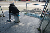 Frankreich,Nantes,44,Stadtviertel Pirmil,junger Mann wartet in einem kaputten Unterstand auf den Bus.