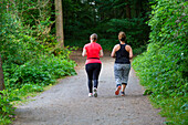 Zwei Frauen aus dem hinteren Teil des Waldes joggen
